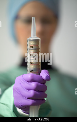 Medical NHS Cash injection coins in syringe held by medic Stock Photo ...