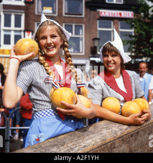 Two Dutch cheese girls in traditional tracht and carrying baskets of ...