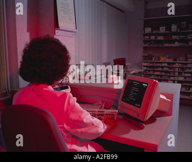 Pharmassist Computer System Pharmacist in pharmacy using computer Stock Photo - Alamy