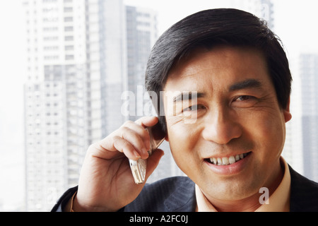 Portrait of a businessman talking on a mobile phone smiling Stock Photo