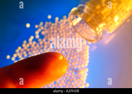 Homeopathic remedy, globule on a fingertip Stock Photo