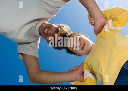 Father and son (4-7) head to head, view from below Stock Photo