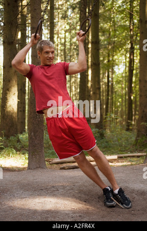 Young man exercising with rings Stock Photo