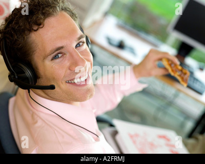 Young man having pizza for lunch, smiling, close-up, portrait Stock Photo