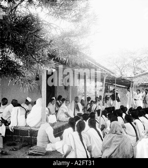 Kasturba Gandhi and Mahatma Gandhi talking to group crowd of girls in Sevagram Ashram Vardha Wardha Maharashtra India 1941 Stock Photo