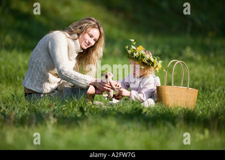 Mother and daughter in meadow, doughter wearing wreath on head Stock Photo