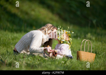 Mother and daughter in meadow, doughter wearing wreath on head Stock Photo