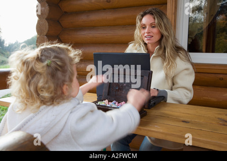 Mother sitting with daughter on table Stock Photo
