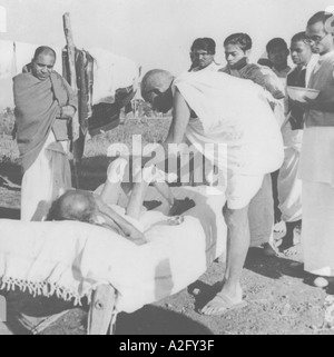 MKG33054 Mahatma Gandhi caring concern giving his daily massage to the leper disease patient Ashram inmate Sanskrit scholar Stock Photo