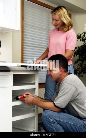Couple installing kitchen cabinets Stock Photo
