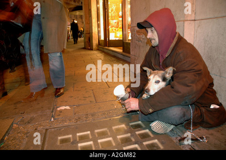 Homeless man begging with his dog on streets of London. Stock Photo