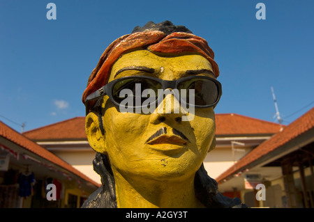 Indonesia Bali Kuta sculpture of Balinese man wearing sunglasses at entrance to shopping center Stock Photo