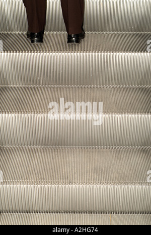 Businessman Going up an Escalator Stock Photo