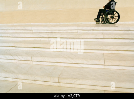 Disabled man in a wheelchair at the top a flight of stone steps Stock Photo