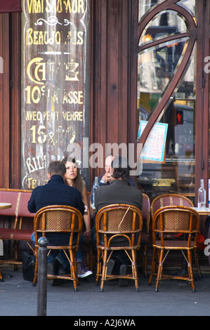 Le Bistrot du Peintre cafe bar terrasse terasse outside seating on the sidewalk. People sitting in chairs at tables eating and drinking outside at lunch time. In the background an old sign saying that coffee costs 10 ten cents, Beaujolais, Saumur The Bistrot du Peintre is an old fashioned Paris café cafe bar restaurant of art nouveau design with polished brass, mirrors and old signs Stock Photo