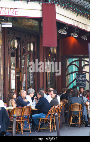 Le Bistrot du Peintre cafe bar terrase outside seating on the sidewalk. People sitting in chairs at tables eating and drinking outside at lunch time. The Bistrot du Peintre is an old fashioned Paris café cafe bar restaurant of art nouveau design with polished brass, mirrors and old signs Stock Photo