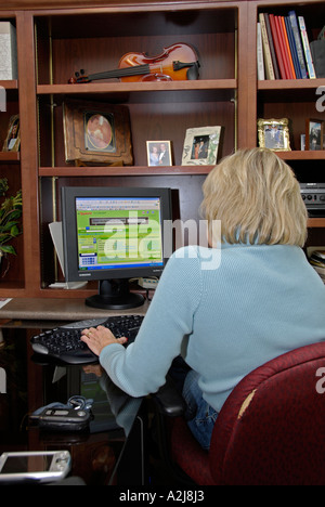 Professional business woman works in a home office situation using a desktop computer Stock Photo
