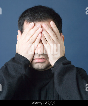 Man covering his eyes with his hands Stock Photo