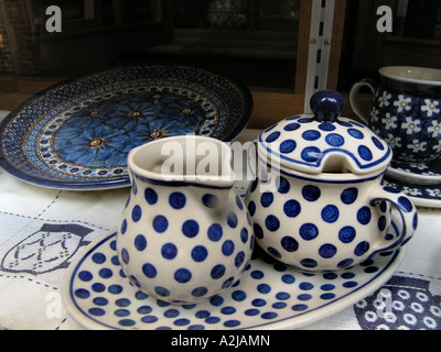 earthenware tea set in white with blue dots on display in shop window Stock Photo
