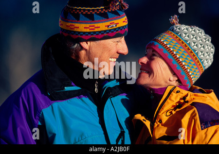 A mature couple gaze into each others eyes outdoors on a cool but sunny day Stock Photo