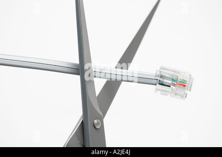 Scissors cutting communications cable Stock Photo