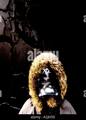 A man age 20-25 wearing a baseball cap and coat with it's hood up so you can't see his face. The picture is taken against an abstract background. Stock Photo