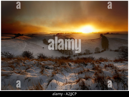 Late evening sun bursts through the mist after a snow fall over the Thixen Dale Valley The Wolds Yorkshire Stock Photo