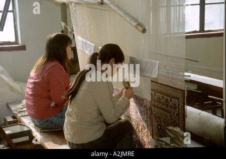 China, Shanghai, Women weaving silk rug at Shanghai Jinxiu Carpet Factory Stock Photo