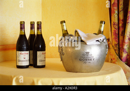 Three bottles of red Chateauneuf du Pape Excellence Cuvee Consuls 1998, three bottles of white Chateauneuf in an ice bucket engraved with champagne Gosset on a table in the restaurant La Mere Germaine in Chateauneuf  Chateauneuf-du-Pape Châteauneuf, Vaucluse, Provence, France, Europe  Chateauneuf-du-Pape Châteauneuf, Vaucluse, Provence, France, Europe Stock Photo