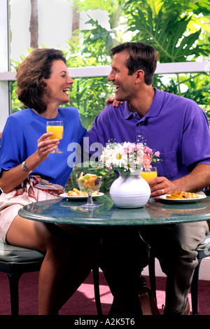 Romantic couple in their 30s having breakfast in hotel atrium on vacation Stock Photo