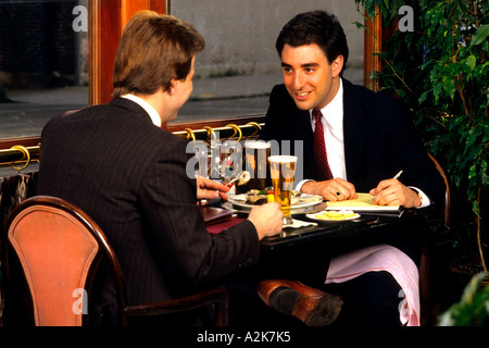 Two men having a power lunch with beer at lunch restaurant discussing business Stock Photo