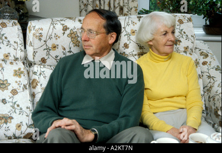 senior couple sitting on sofa having argument Stock Photo