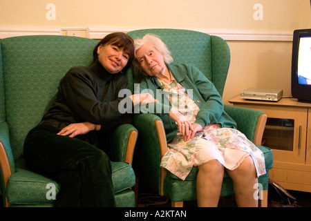 middle aged portrait woman/daughter/care worker with very old lady/her mother in nursing home Stock Photo
