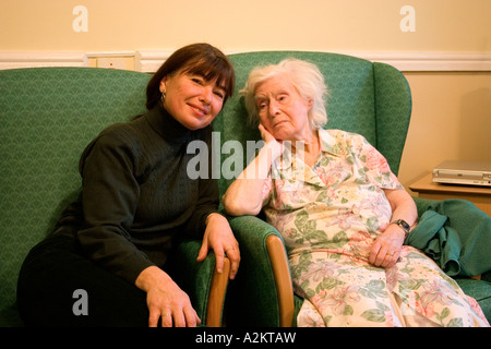 middle aged portrait woman/daughter/care worker with very old lady/her mother in nursing home Stock Photo