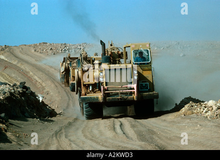 Huge Caterpillar tractor belching smoke building roads Saudi Arabia Stock Photo