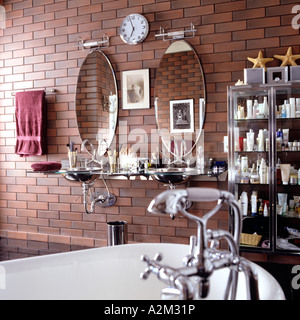 Shower fitting and mirrors in bathroom with brick wall Stock Photo