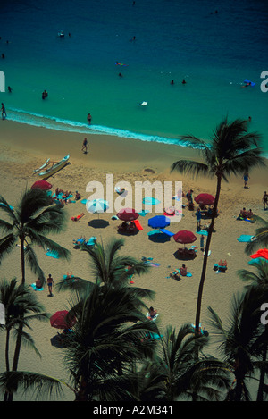 Aerial view of Palm trees umbrellas and vacationers on a tropical beach Stock Photo