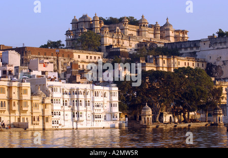 View over Lake Pichola towards City Palace and Jagat Niwas Hotel white hotel on water s edge Udaipur Rajasthan India Stock Photo