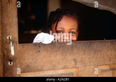 Latch key kid young ethnic real black girl window broken screen door of apartment in Atlanta Georgia America Stock Photo