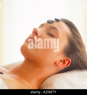 Close-up of young woman receiving hot stone treatment Stock Photo