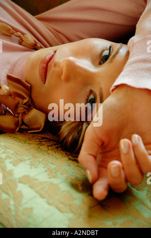 Portrait of young woman lying on bed Stock Photo