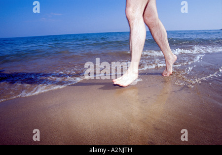 Low section view of man running on beach Stock Photo