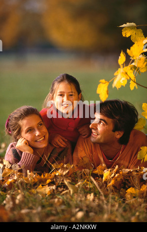 Family lying on grass in a park Stock Photo