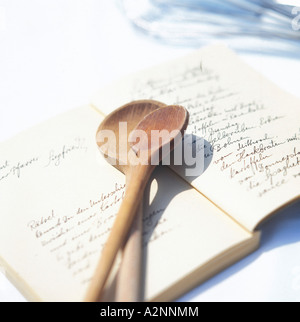 Close-up of wooden spoons on recipe book Stock Photo