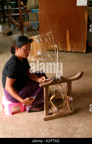 Laos Vientiane woman hand spinning silk and winding onto bobbin Stock Photo