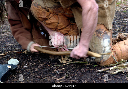 Professional stoneage reenactors trying to make fire at The Museum of Welsh Life St Fagans Cardiff Wales UK Stock Photo