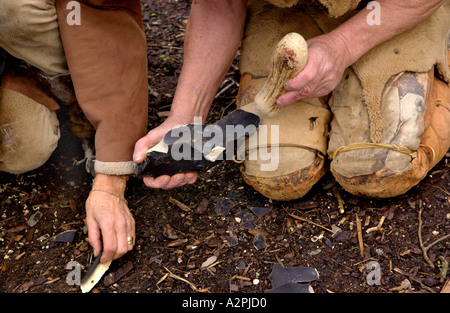 prehistoric man Professional Stoneage reenactors knapping flint at The Museum of Welsh Life St Fagans Cardiff Wales UK Stock Photo