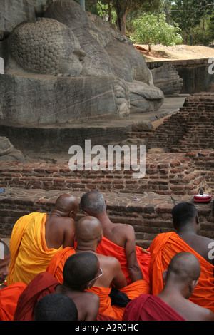 Orange robe clad monks at a gathering, Val Gihara Statue of the reclining buddha in Polonnaruwa, Sri Lanka Stock Photo