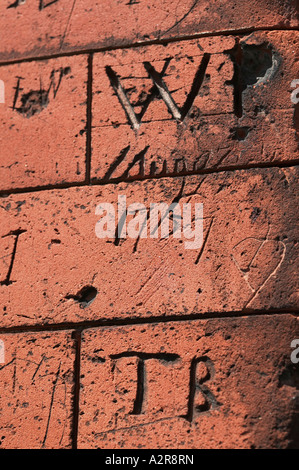 Graffiti craved in brickwork on old school walls Dedham North Essex UK Great Britain England Stock Photo