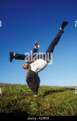 Brazilian male in business suit doing handstand Stock Photo